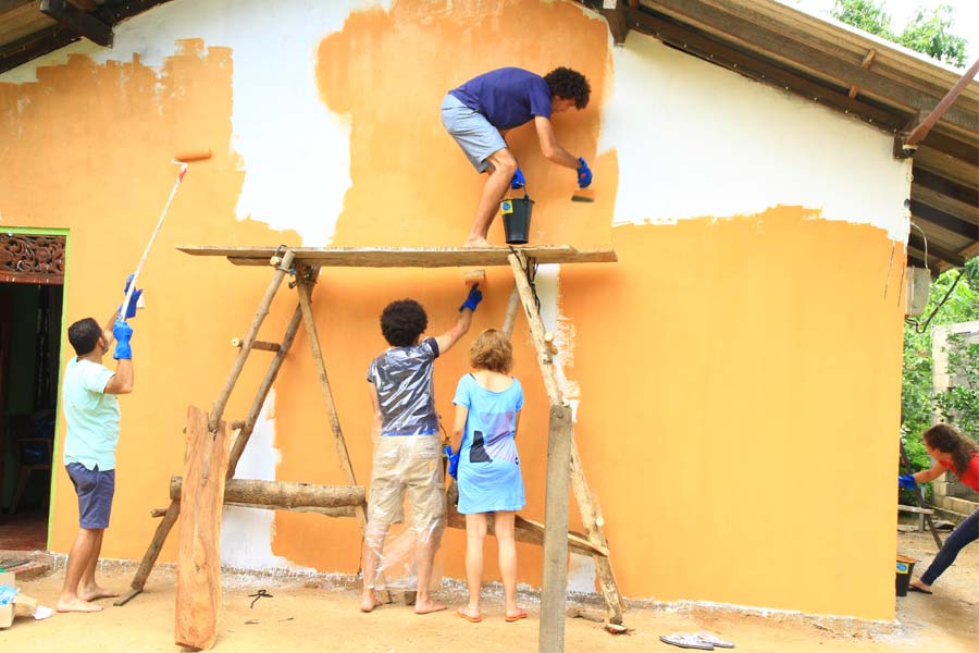A group of tourists painting houses in their tuk tuk challenge in Sri Lanka 